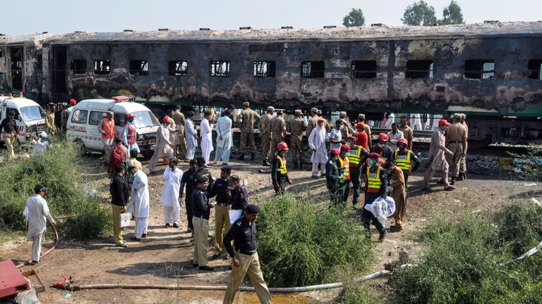 Les pompiers travaillent pour calmer les wagons brûlés après l'incendie d'un train de passagers qui a pris feu près de Rahim Yar Khan dans la province du Punjab le 31 octobre 2019