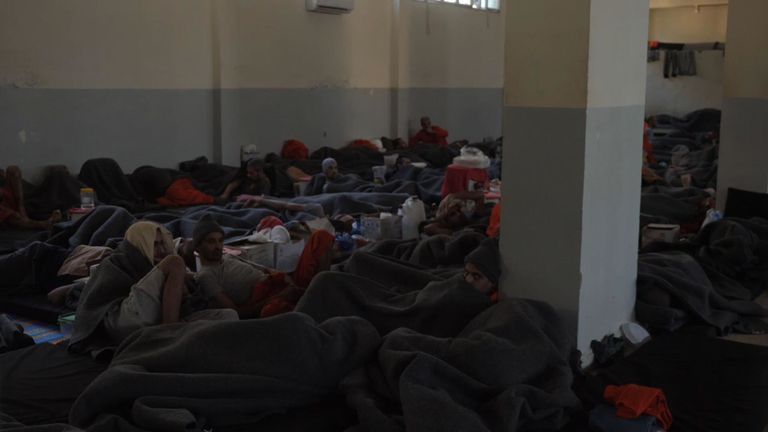 Des dizaines de prisonniers sont coupés dans une grande pièce, tandis que d'autres sont regroupés dans des cellules