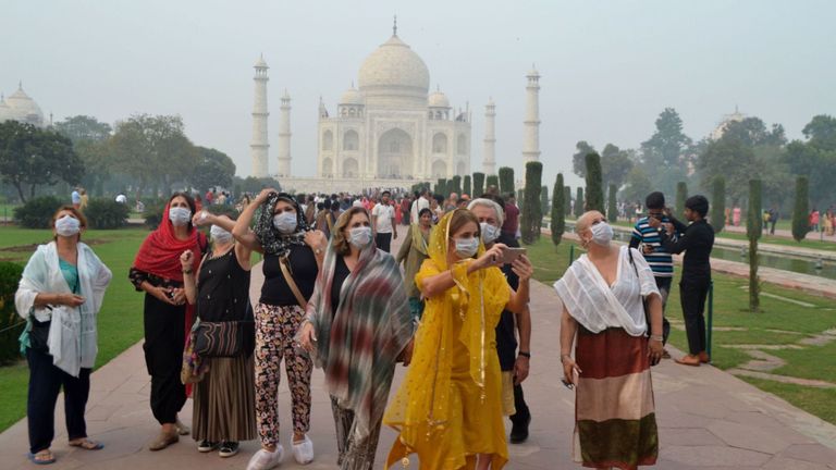 Les touristes étrangers portent des masques lors de la visite du Taj Mahal dans un brouillard épais 
