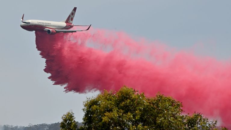 Un avion du service d'incendie de NSW en milieu rural lâche un retardateur de feu sur un feu de brousse incontrôlé près de Taree, à 350 km au nord de Sydney, le 12 novembre 2019
