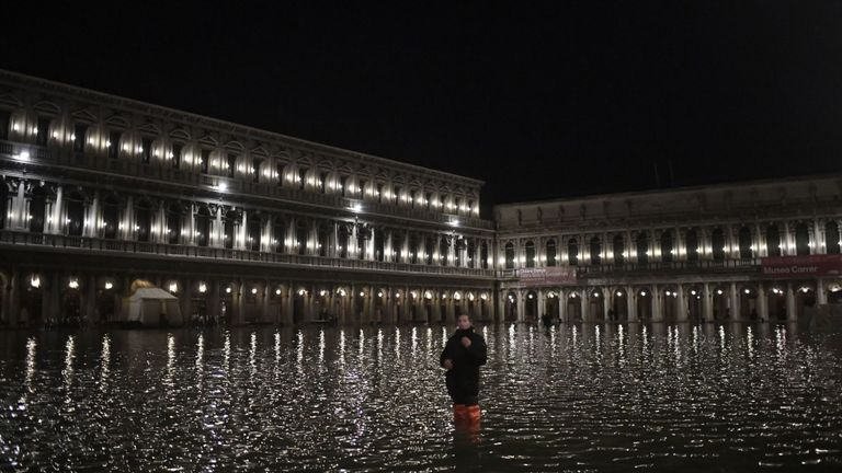 Une personne traverse la place inondée de Saint-Marc lors d’une marée haute exceptionnelle "Alta Acqua" le 12 novembre 2019 à Venise.