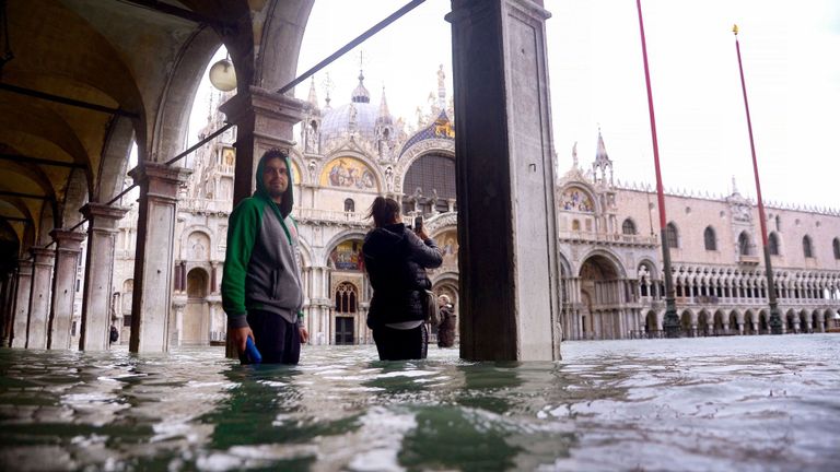 Les gens prennent des photos d'une arcade inondée 