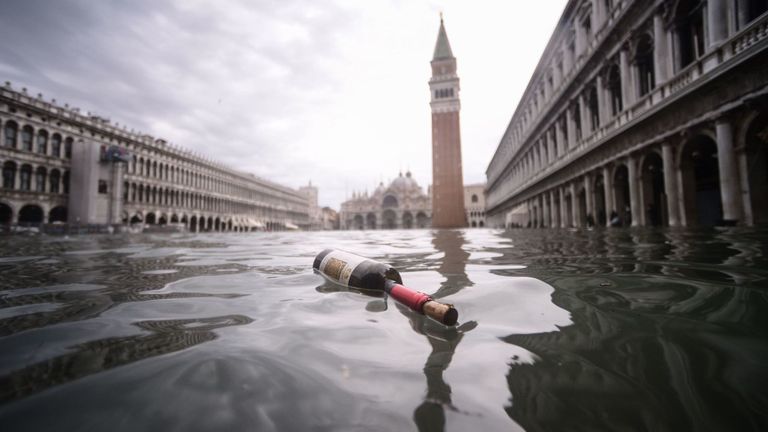 Une vue générale montre une bouteille de vin flottant sur l’eau de la place St Marc inondée.
