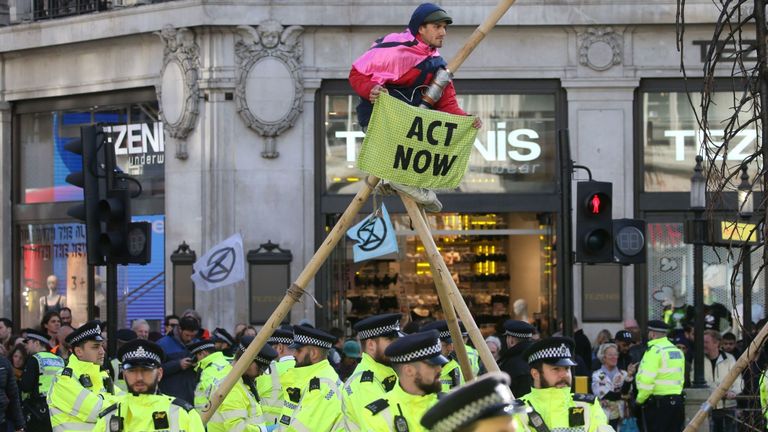 La police surveille un activiste du climat perché sur une structure de fortune à Oxford Street lors de la douzième journée de manifestations du groupe d'action contre le changement climatique Extinction Rebellion