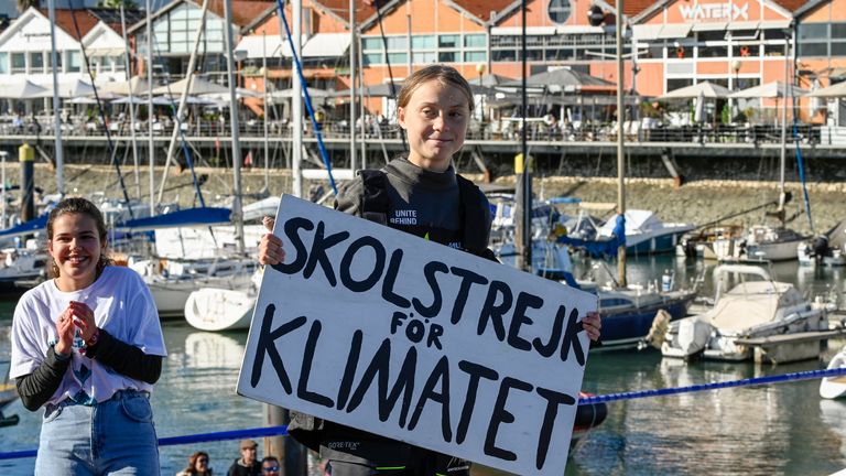 LISBONNE, PORTUGAL - 03 DÉCEMBRE: Greta Thunberg, activiste suédoise pour le climat chez les adolescentes, montre la pancarte "Grève des écoles pour le climat", qu'elle a organisée devant le parlement suédois, à son arrivée au quai de loisirs de Santo Amaro le 03 décembre 2019 à Lisbonne, au Portugal. Greta Thunberg est partie de Norfolk, en Virginie (États-Unis), accompagnée de son père, Svante Thunberg, à bord du catamaran français La Vagabonde, construit par Outremer 45, sous la direction de l'Australien Riley Whitelum, et se rend à la COP25 à Madrid, en Espagne. (Photo de Horacio Villalobos / Getty Images)