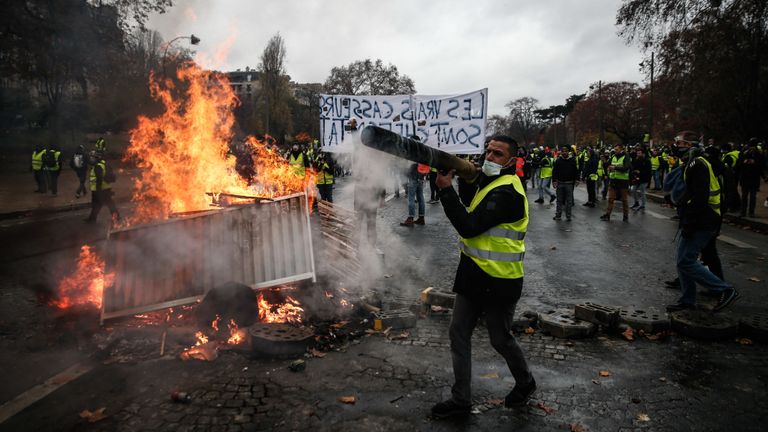 TOPSHOT - Les manifestants construisent une barricade lors d'une manifestation des Gilets jaunes (Gilets jaunes) contre la hausse des prix du pétrole et du coût de la vie, le 1er décembre 2018 à Paris. (Photo par Abdulmonam EASSA / AFP) (Le crédit photo doit se lire ABDULMONAM EASSA / AFP via Getty Images)