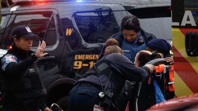 Une femme reçoit des soins médicaux sur les lieux d'une fusillade active à Jersey City le 10 décembre 2019. - Un officier a été abattu lorsque deux hommes armés avec un long fusil ont ouvert le feu à Jersey City (New Jersey) dans l'après-midi du 10 décembre. 2019, selon deux responsables. Deux suspects ont été barricadés dans un dépanneur, ont indiqué les responsables. Un officier était emmené dans un hôpital voisin. (Photo par Kena Betancur / AFP) (Photo par KENA BETANCUR / Afp / AFP via Getty Images)