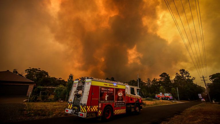 Les pompiers se préparent alors qu'un feu de brousse s'approche des maisons à la périphérie de la ville de Bargo