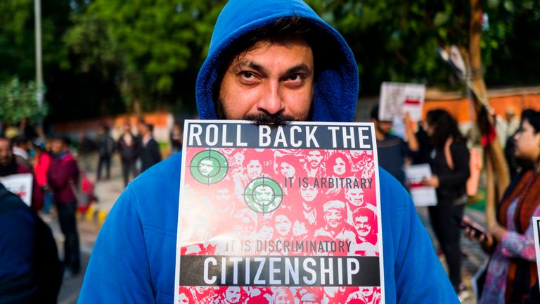 Un manifestant affiche une pancarte lors d'une manifestation contre la nouvelle loi du gouvernement indien