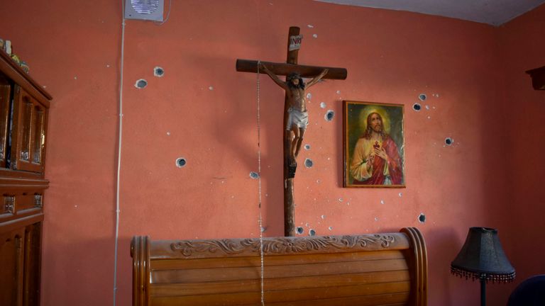 Un mur de la pièce d'une maison est criblé de balles