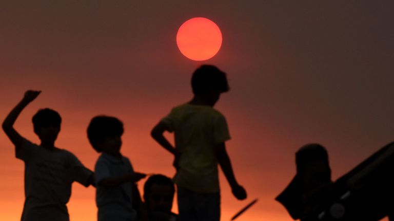 Une famille sur une plage de Sydney le 4 décembre alors qu'une brume de fumée continue de planer sur la ville avec plus de 50 feux de brousse en Nouvelle-Galles du Sud