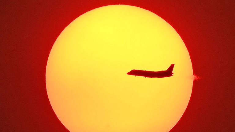 L'avion survole le soleil couchant à Sydney le 4 décembre alors qu'une brume de fumée continue de planer sur la ville avec plus de 50 feux de brousse encore en feu à travers la Nouvelle-Galles du Sud