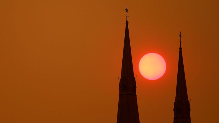 Le soleil se couche derrière la cathédrale St Mary à Sydney le 6 décembre 2019. La plupart des NSW restent sous des avertissements de danger d'incendie sévères ou très élevés alors que plus de 50 incendies continuent de brûler à travers l'État