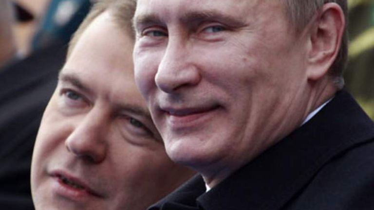Le président russe Dmitri Medvedev (L) et le Premier ministre Vladimir Poutine parlent alors qu'ils regardent un défilé militaire sur la Place Rouge 
