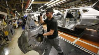 Un membre du personnel de fabrication de Nissan enlève la portière d'un véhicule alors qu'il travaille dans la section «Trim and Châssis» de leur usine de Sunderland à Sunderland.