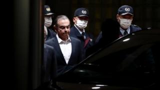 Carlos Ghosn est escorté alors qu'il sort de la maison de détention de Tokyo après sa libération sous caution à Tokyo en avril 2019