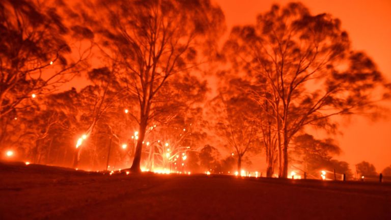 Le 31 décembre 2019, le ciel de l'après-midi devient orange à cause des feux de brousse dans la région de Nowra, dans l'État australien de la Nouvelle-Galles du Sud. - Des milliers de vacanciers et d'habitants ont été forcés de fuir vers les plages du sud-est de l'Australie ravagée par le feu le 31 décembre. , alors que des flammes déchiraient les zones touristiques populaires sans laisser de fuite par la terre. (Photo par Saeed KHAN / AFP) (Photo par SAEED KHAN / AFP via Getty Images)