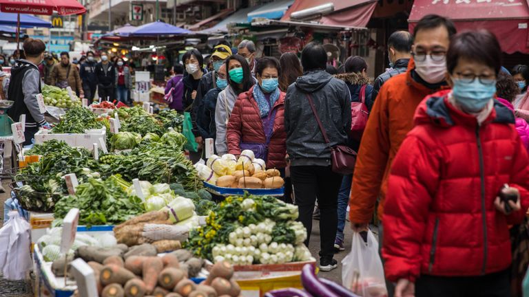 Les acheteurs de Hong Kong portent des masques alors que le gouvernement ferme certaines parties de la frontière avec la Chine