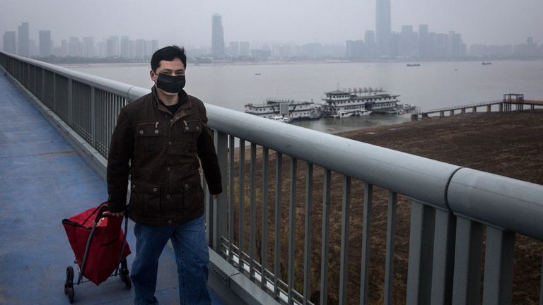WUHAN, CHINE - 27 JANVIER: Un homme porte un masque tout en faisant glisser une charrette. à Yangtze River Bridge le 27 janvier 2020 à Wuhan, dans la province du Hubei, en Chine. Les transports en commun ont été fermés pour le quatrième jour. (Photo par Getty Images)