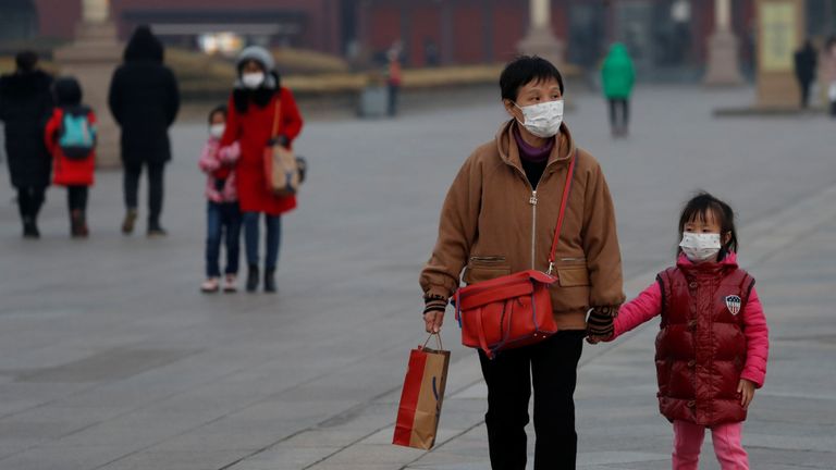 Des personnes portant des masques faciaux marchent à la porte de Tiananmen, alors que le pays est frappé par une épidémie du nouveau coronavirus, à Pékin, en Chine, le 27 janvier 2020. REUTERS / Carlos Garcia Rawlins