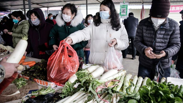 Les résidents portent des masques pour acheter des légumes sur le marché le 23 janvier 2020 à Wuhan, Hubei¬China