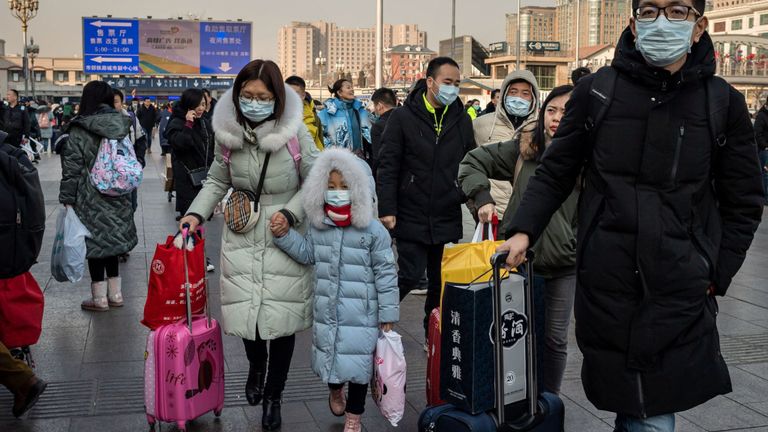 Des personnes portant des masques de protection arrivent à la gare de Pékin pour rentrer chez elles pour le nouvel an lunaire le 21 janvier 2020