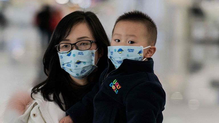Une femme et son enfant portent des masques de protection dans la capitale chinoise