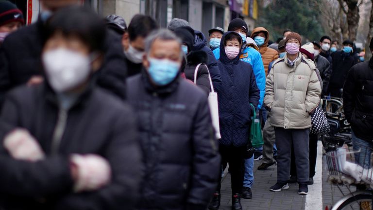 Des gens font la queue devant une pharmacie pour acheter des masques à Shanghai