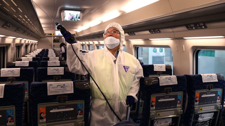 Un travailleur de la désinfection portant des engrenages de protection pulvérise une solution anti-septique dans un train à Séoul, Corée du Sud