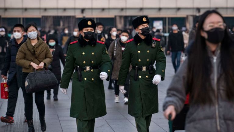 Des policiers chinois portent des masques de protection lorsqu'ils patrouillent à la gare de Pékin