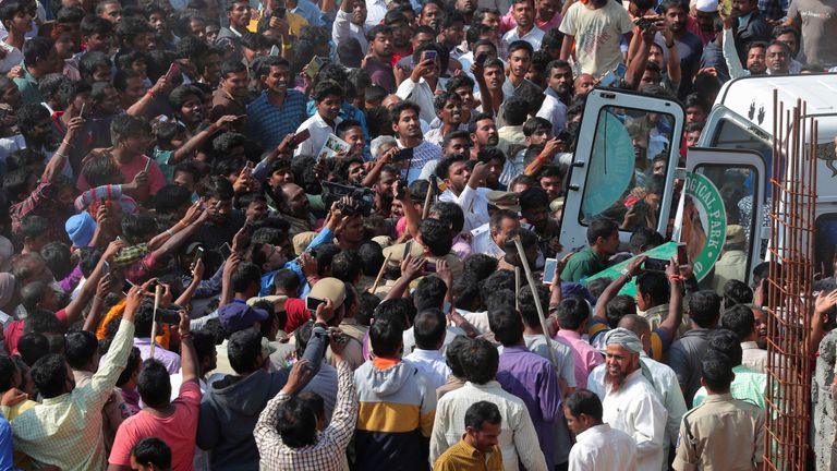 Les gens prennent des photos alors que les responsables de la faune indienne portent un léopard tranquille qui a été trouvé sur la terrasse d'une maison à Shadnagar à 55 kilomètres ((34 miles) de Hyderabad, en Inde, le lundi 20 janvier 2020. Un léopard qui a couru dans une maison et a déclenché une recherche effrénée dans le sud de l'Inde lundi a été capturé et apaisé (AP Photo / Mahesh Kumar A.)                                            