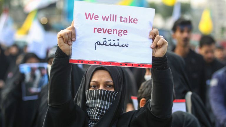 Une femme irakienne tient une pancarte lors des funérailles du général de division Qasem Soleimani et de neuf autres