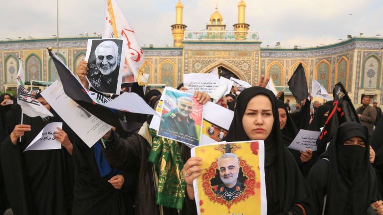 Les personnes en deuil tenant des photos du Gén Maj Soleimani attendent le cortège funèbre à l'extérieur de la mosquée Imam Abbas à Karbala, dans le centre de l'Iraq