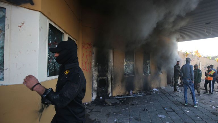De la fumée s'échappe de l'entrée de l'ambassade américaine à Bagdad après que des manifestants ont tenté de s'introduire dans le bâtiment