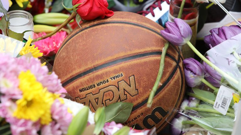 Un ballon de basket se trouve au milieu des fleurs dans un sanctuaire de fortune au Staples Center à Los Angeles /