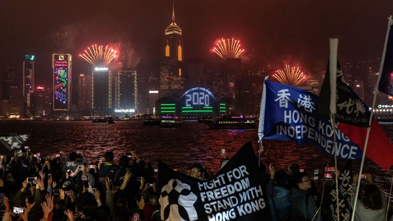 Des partisans de la démocratie agitent des drapeaux et crient des slogans lors d'un compte à rebours dans le district de Tsim Sha Tsui