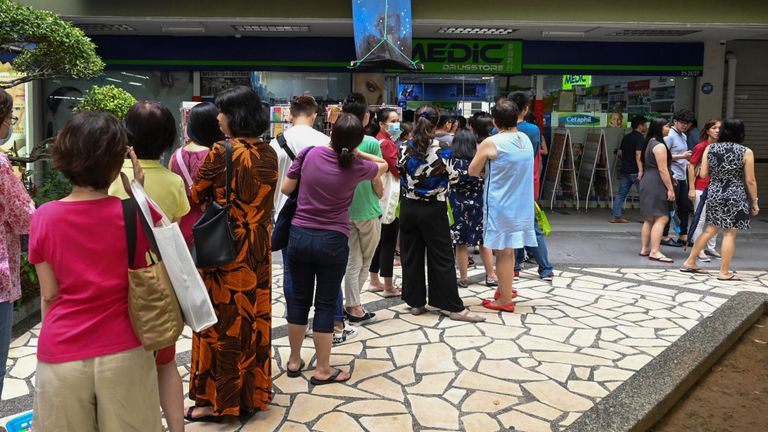 Files d'attente pour les masques de protection dans un magasin de médicaments à Singapour