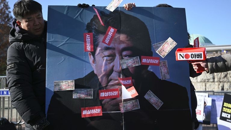 Des manifestants sud-coréens tiennent une bannière montrant une photo du Premier ministre japonais Shinzo Abe 