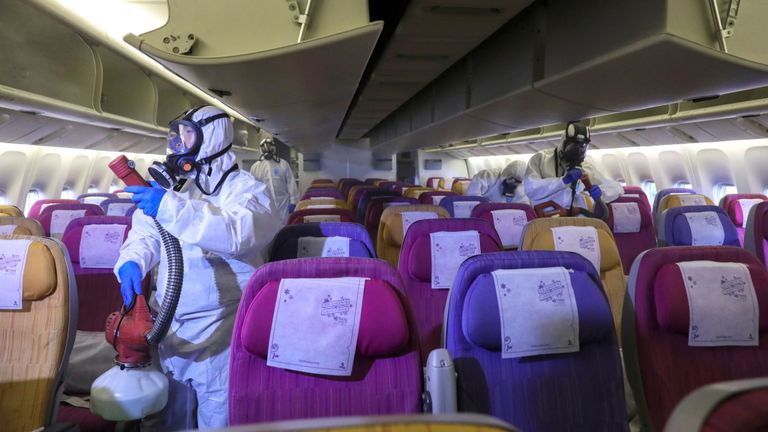 Des membres de l'équipage de Thai Airways désinfectent la cabine d'un avion du transporteur national au cours d'une procédure visant à empêcher la propagation du coronavirus à l'aéroport international Suvarnabhumi de Bangkok