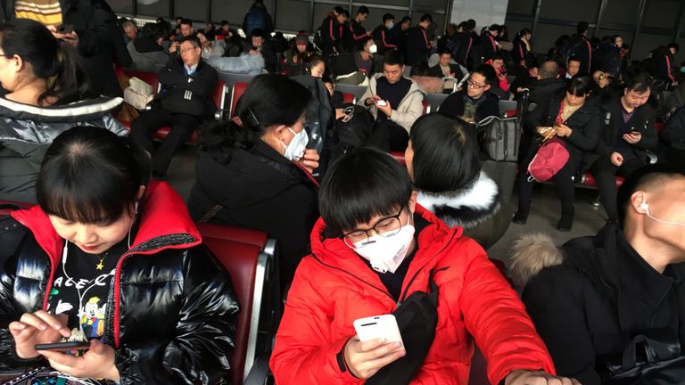 Les passagers portant des masques attendent leur train pour Wuhan à Beijing West Railway avant le nouvel an chinois