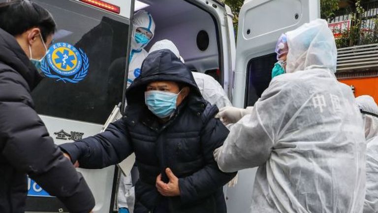 Un patient est enlevé d'une ambulance à Wuhan - l'épicentre de l'épidémie