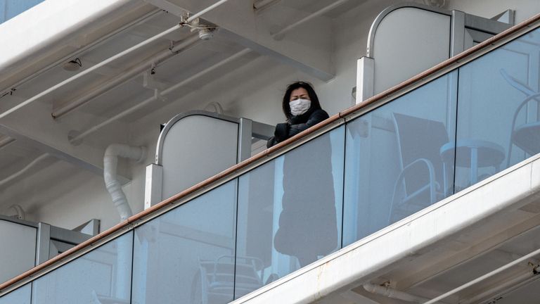 Les passagers à bord du bateau de croisière Diamond Princess regardent depuis leur balcon tandis que le navire accoste au terminal de croisière de la jetée de Daikoku dans le port de Yokohama le 6 février 2020. - Dix autres personnes sur le bateau de croisière au large des côtes du Japon ont été testées positives pour le nouveau coronavirus, a déclaré le ministre de la Santé le 6 février, portant le nombre d'infections détectées sur le bateau à 20. (Photo de Kazuhiro NOGI / AFP) (Photo de KAZUHIRO NOGI / AFP via Getty Images)
