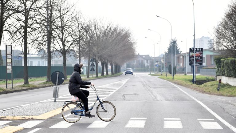 Une personne portant un masque facial fait du vélo dans la ville de Codogno, qui a été fermée par le gouvernement italien en raison d'une épidémie de coronavirus dans le nord de l'Italie, le 23 février 2020. REUTERS / Flavio Lo Scalzo
