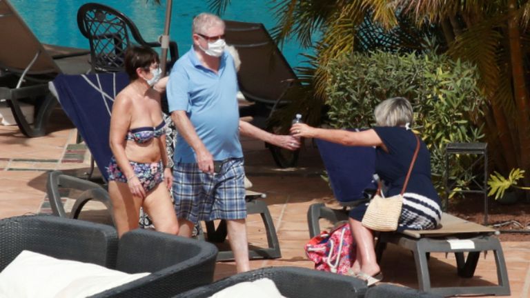 Des touristes avec des masques sont vus près de la piscine du H10 Costa Adeje Palace, qui est en lock-out après que des cas de coronavirus ont été détectés à Adeje, sur l'île espagnole de Tenerife, en Espagne, le 26 février 2020. REUTERS / Borja Suarez