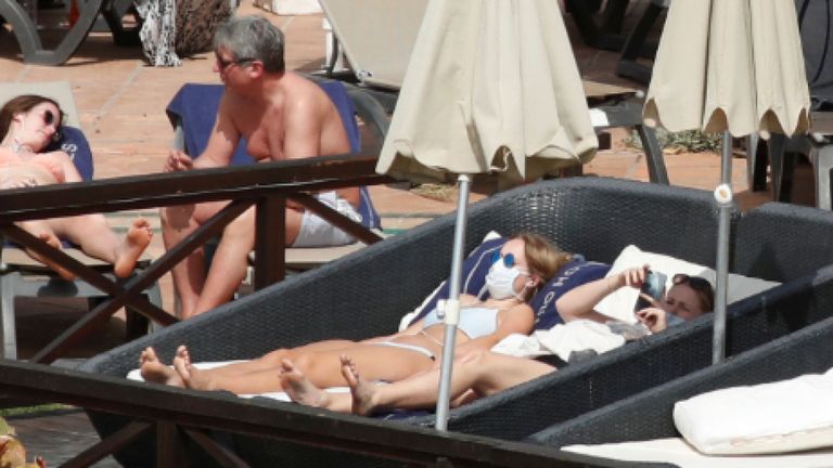 Touristes avec des masques dans la piscine du H10 Costa Adeje Palace, qui est en lock-out après que des cas de coronavirus ont été détectés à Adeje, sur l'île espagnole de Tenerife, Espagne, le 26 février 2020. REUTERS / Borja Suarez