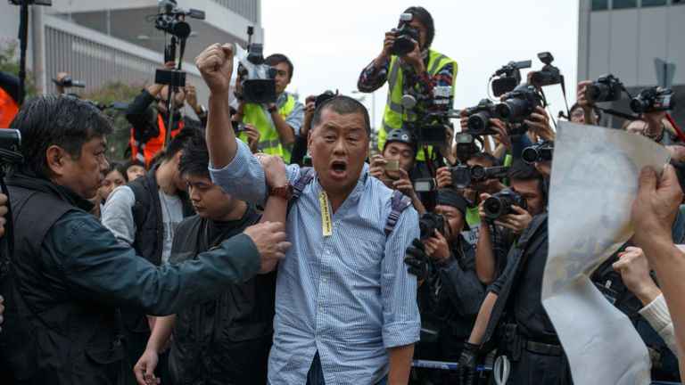 Le propriétaire du journal Tycoon et Apple Daily Jimmy Lai crie un slogan avant qu'il ne soit emmené par un officier de police dans une zone précédemment bloquée par des partisans de la démocratie, à l'extérieur du siège du gouvernement à Hong Kong, le 11 décembre 2014. Les autorités de Hong Kong ont commencé jeudi à dégager le principal site de protestation pro-démocratie qui a obstrué les routes dans le quartier le plus important économiquement et politiquement de la ville pendant plus de deux mois dans le cadre d'une campagne pour exiger des élections libres. REUTERS / Athit Perawongmetha (CHINE - Tags: POLITIQUE DES AFFAIRES CIVILES UNREST)