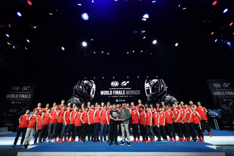 Pilote de Formule 1, Lewis Hamilton et producteur de Gran Turismo, Kazunori Yamauchi posent pour une photo sur scène avec les concurrents