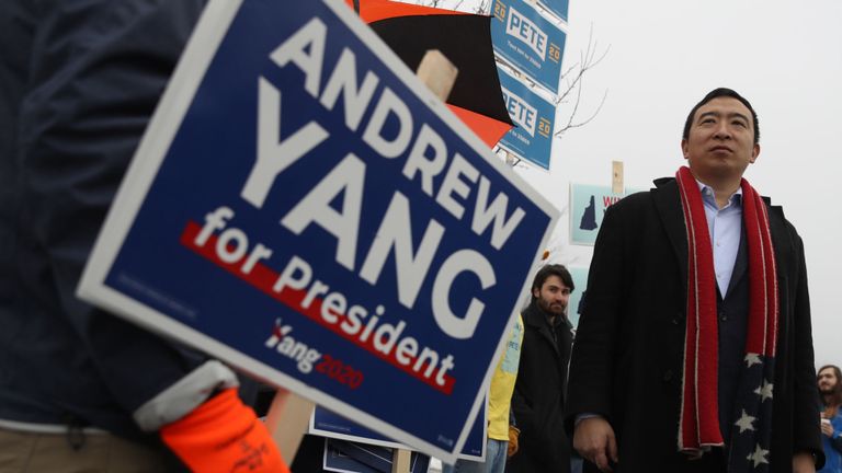 Le candidat démocrate à la présidentielle Andrew Yang salue ses partisans qui tiennent des pancartes devant un bureau de vote le 11 février 2020 à Keene, New Hampshire