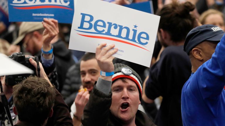 Un supporter de Bernie Sanders applaudit et salue une affiche dans le New Hampshire