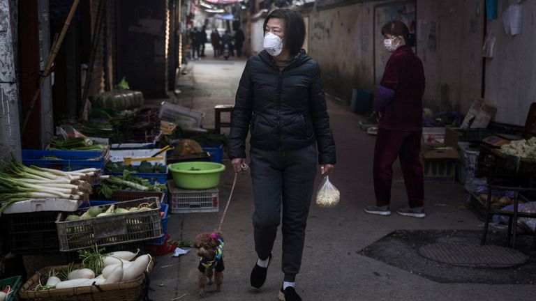 WUHAN, CHINE - 31 JANVIER: (CHINE OUT) Une femme porte un masque de protection lorsqu'elle promène son chien et achète des légumes dans une ruelle le 31 janvier 2020 à Wuhan, en Chine. Le directeur général de l'Organisation mondiale de la santé (OMS), Tedros Adhanom Ghebreyesus, a déclaré le 30 janvier que la nouvelle éclosion de coronavirus est devenue une urgence de santé publique de portée internationale (USPPI). (Photo par Stringer / Getty Images)
